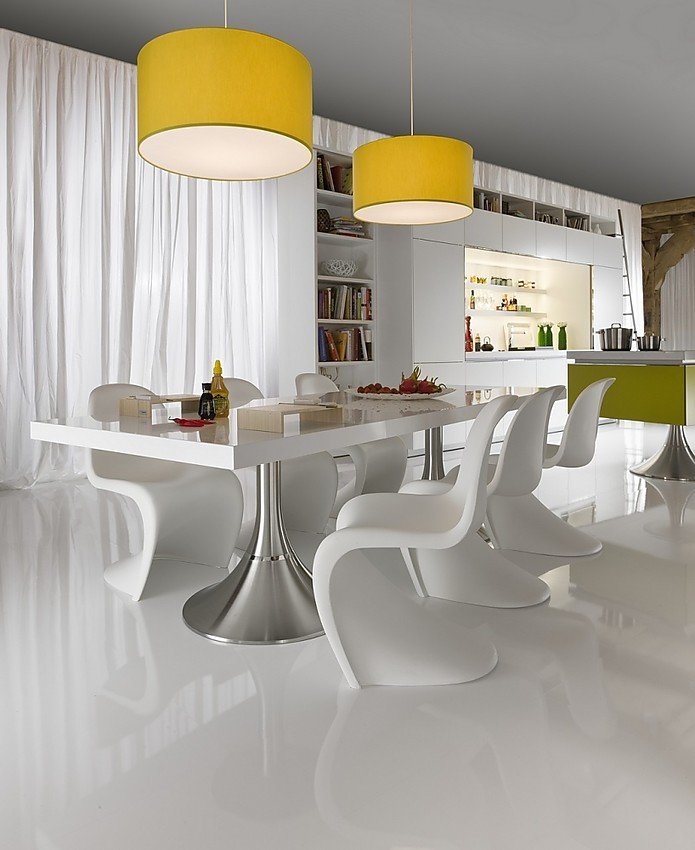 Hier ziet u de Library keuken met in de voorgrond de tafel met twee ronde metallic poten en de elegant gevormde witte stoelen. Zuordnung: Stil Luxe keukens, Planungsart Keuken met keukeneiland